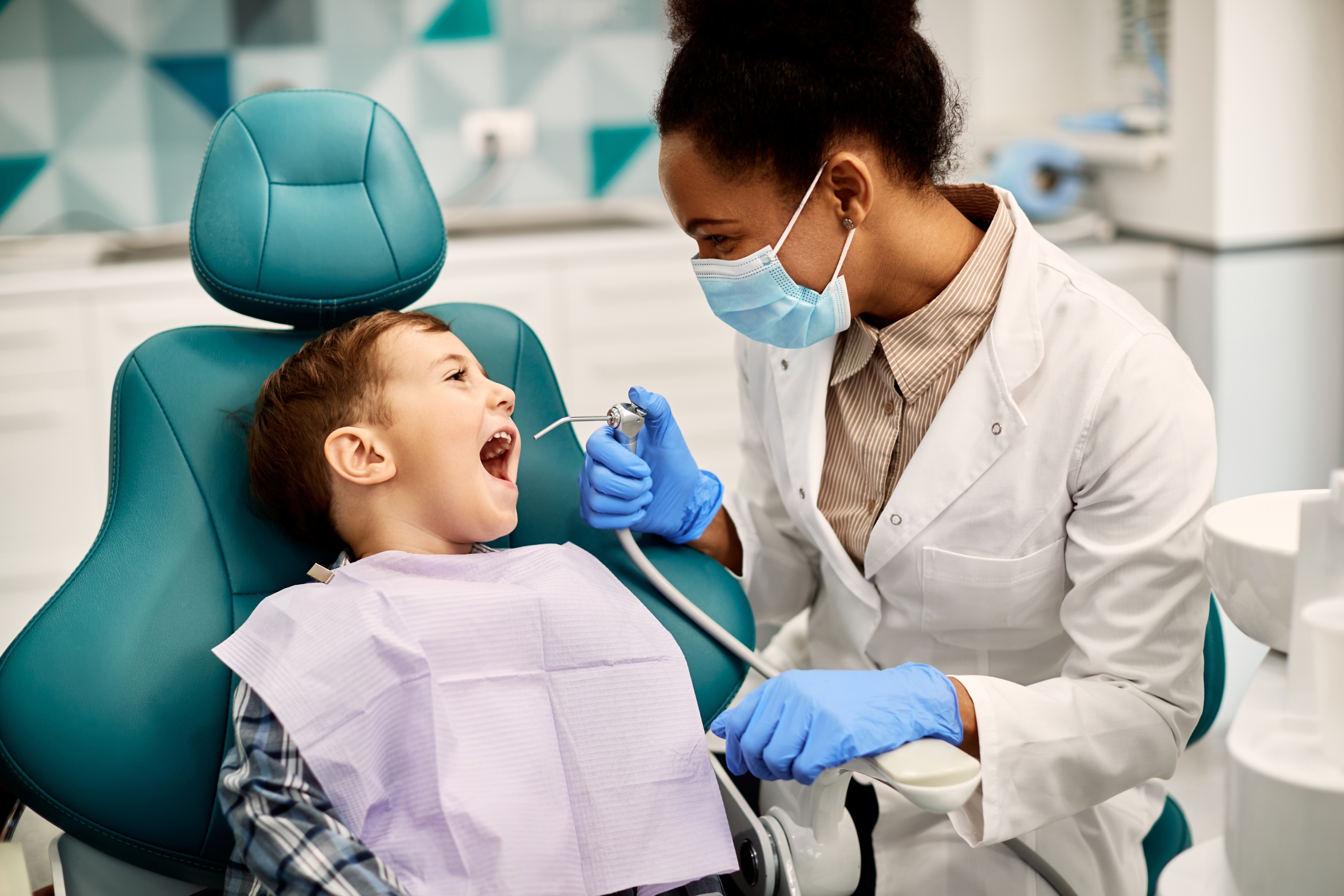 pediatric dentist making child laugh in dental chiar