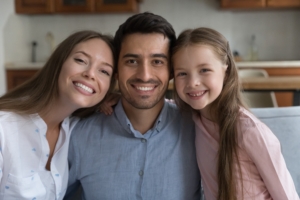 family smiling after visiting dentist with white teeth