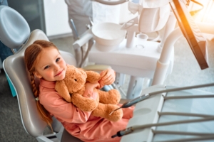 child sitting in chair at pediatric dentist