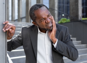 man outside office suffering from painful dental emergency