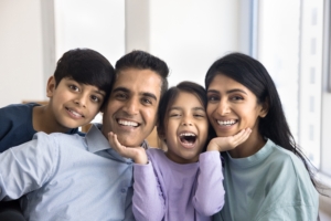 young family smiling all sitting next to eachother