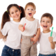 three little kids happy while holding their tooth brush