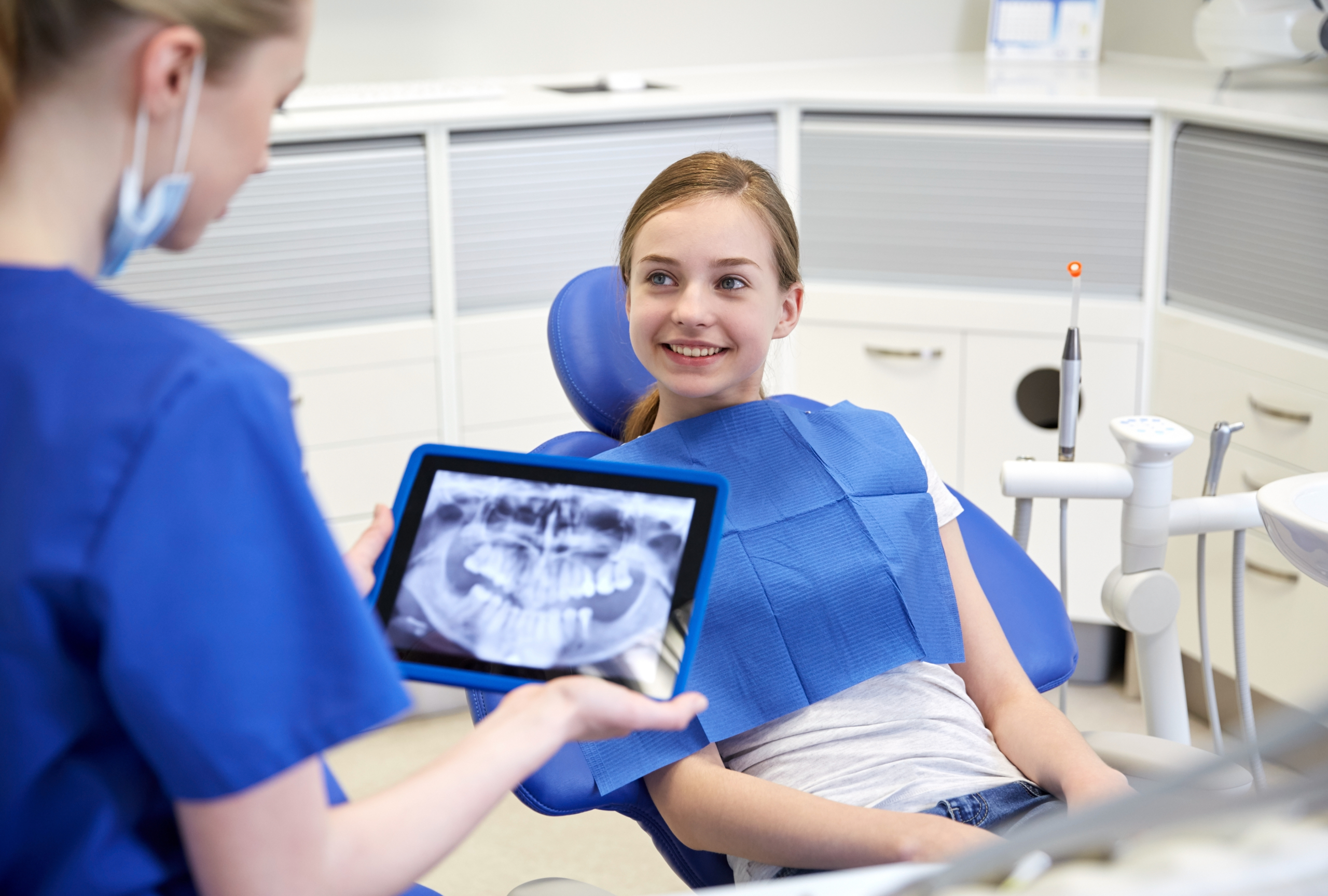 girl at dentist looking at dental x-rays